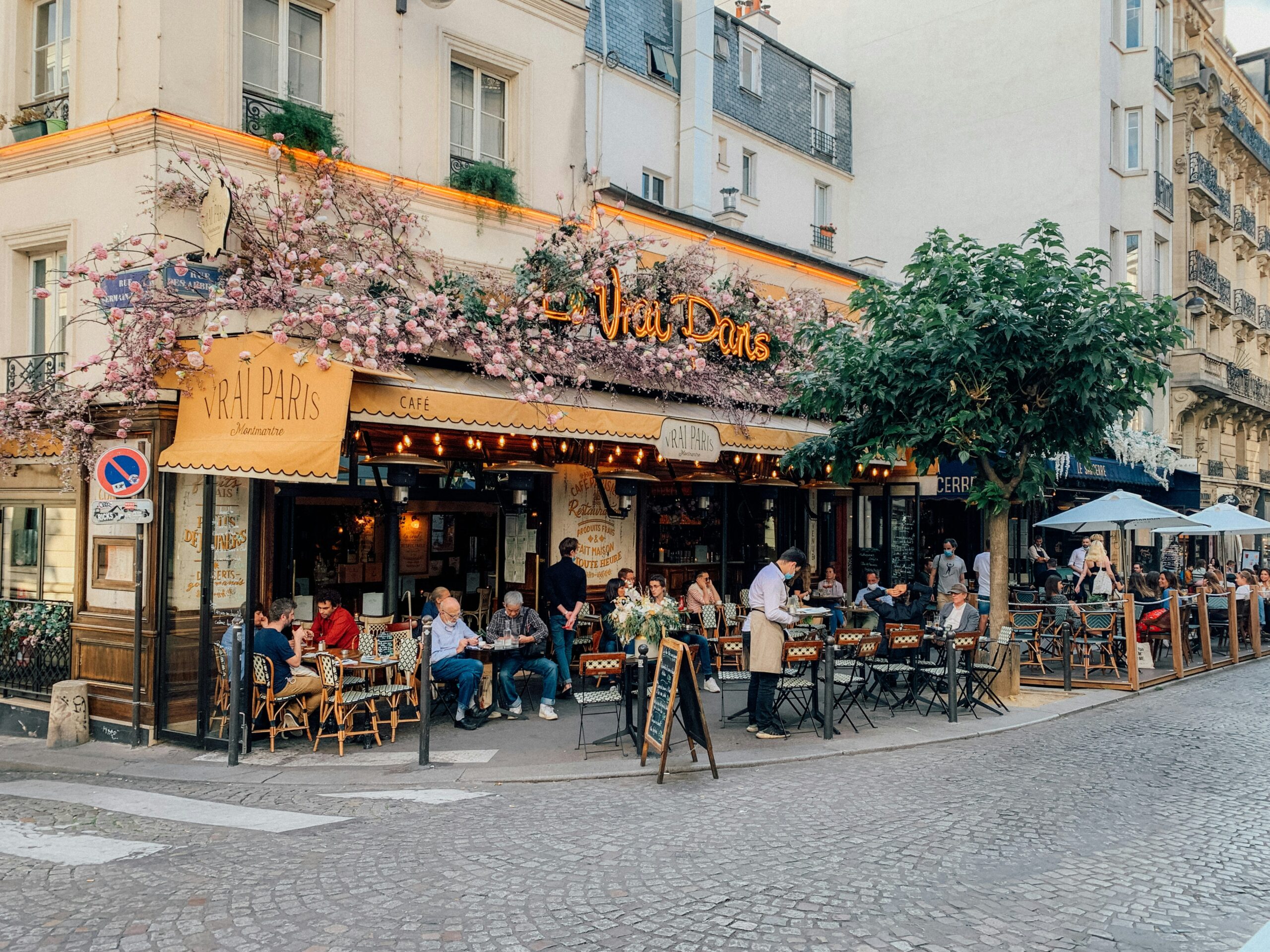People sitting outside of Le Vrai Paris eating, talking, and drinking.