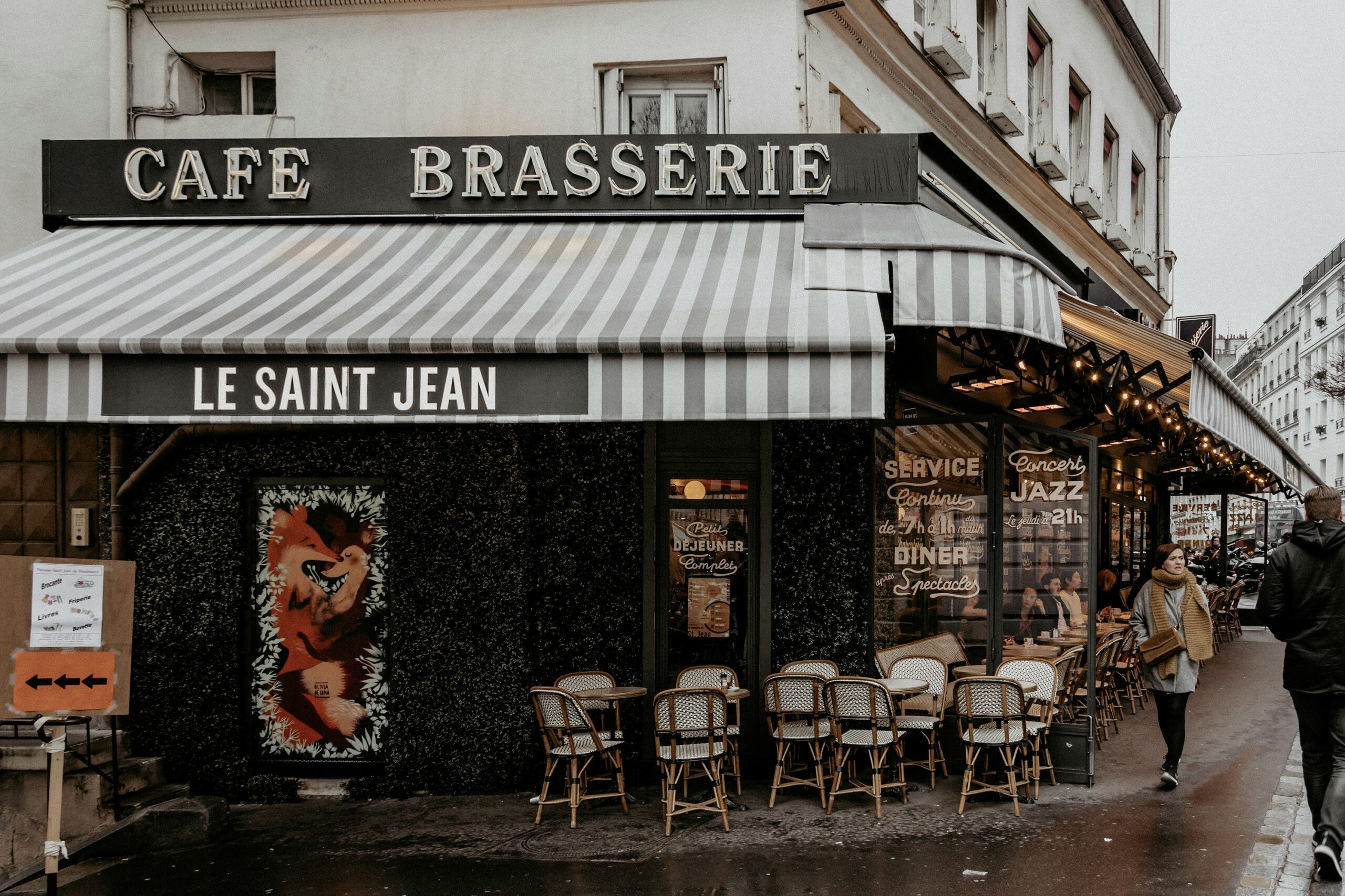 Black and white stripped awning and signage for Le Saint Jean, a Parisian Brasserie